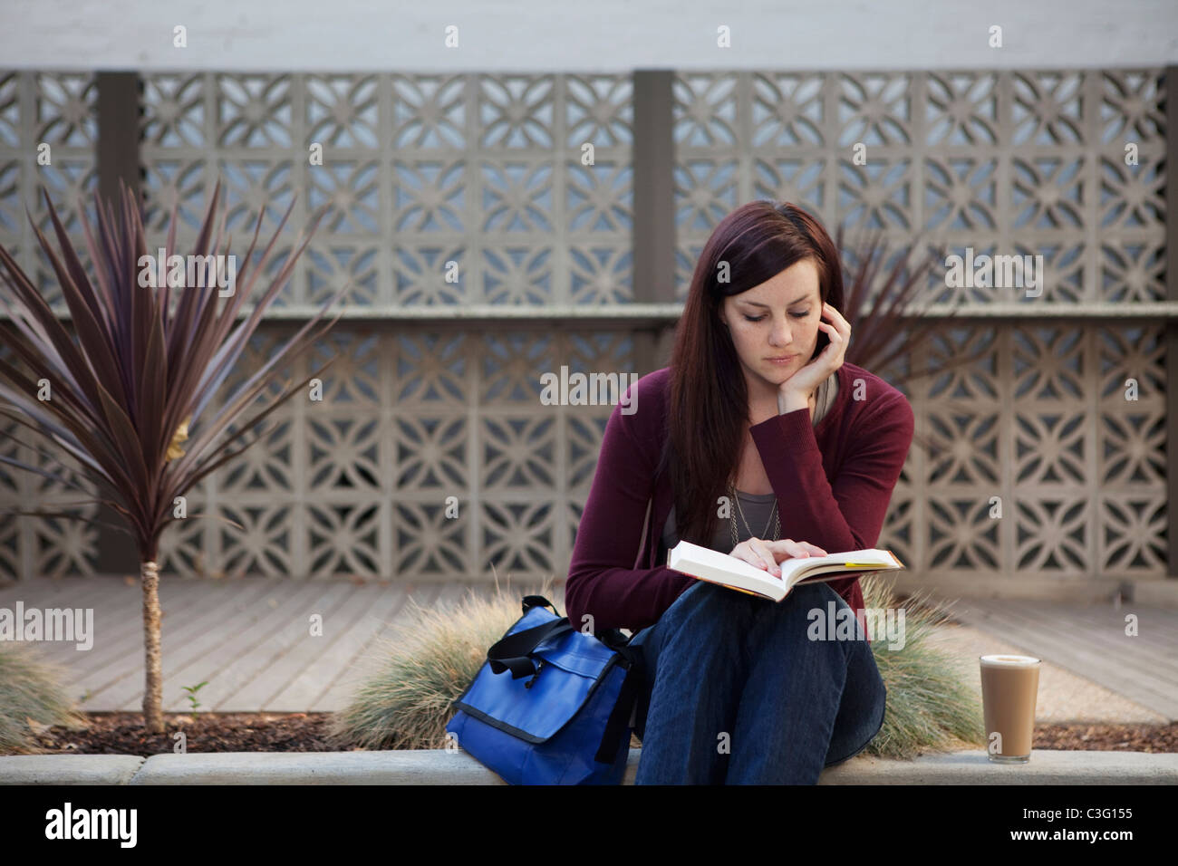 Caucasian woman reading book outdoors Stock Photo