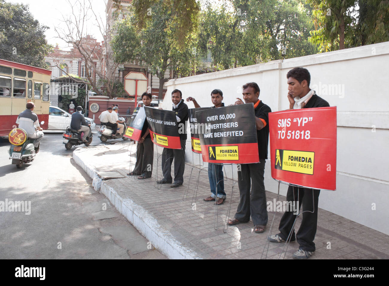 Men holding banner at the roadside, Ahmedabad, Gujarat, India Stock Photo