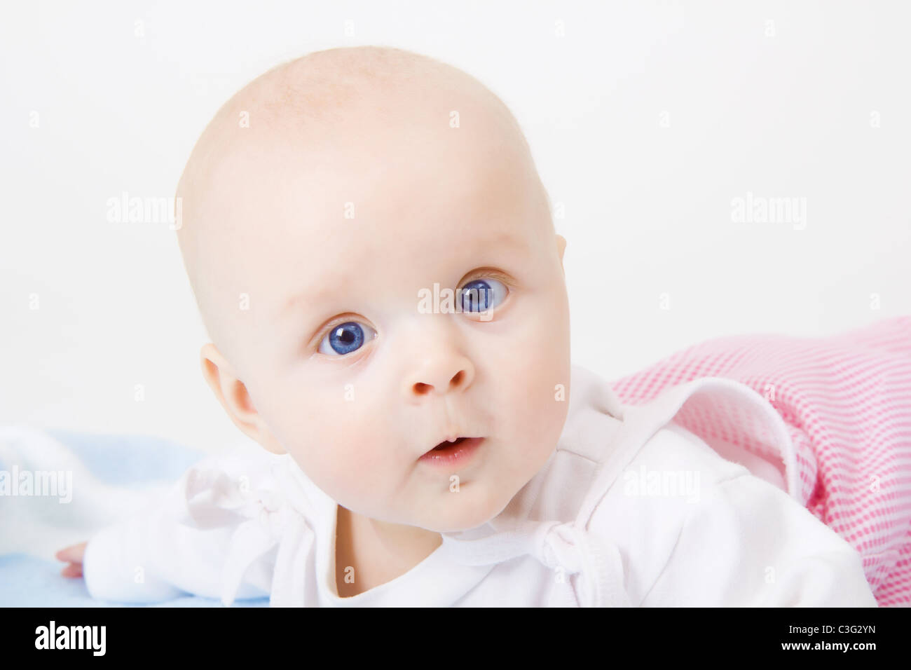 baby girl lying on a white background Stock Photo - Alamy