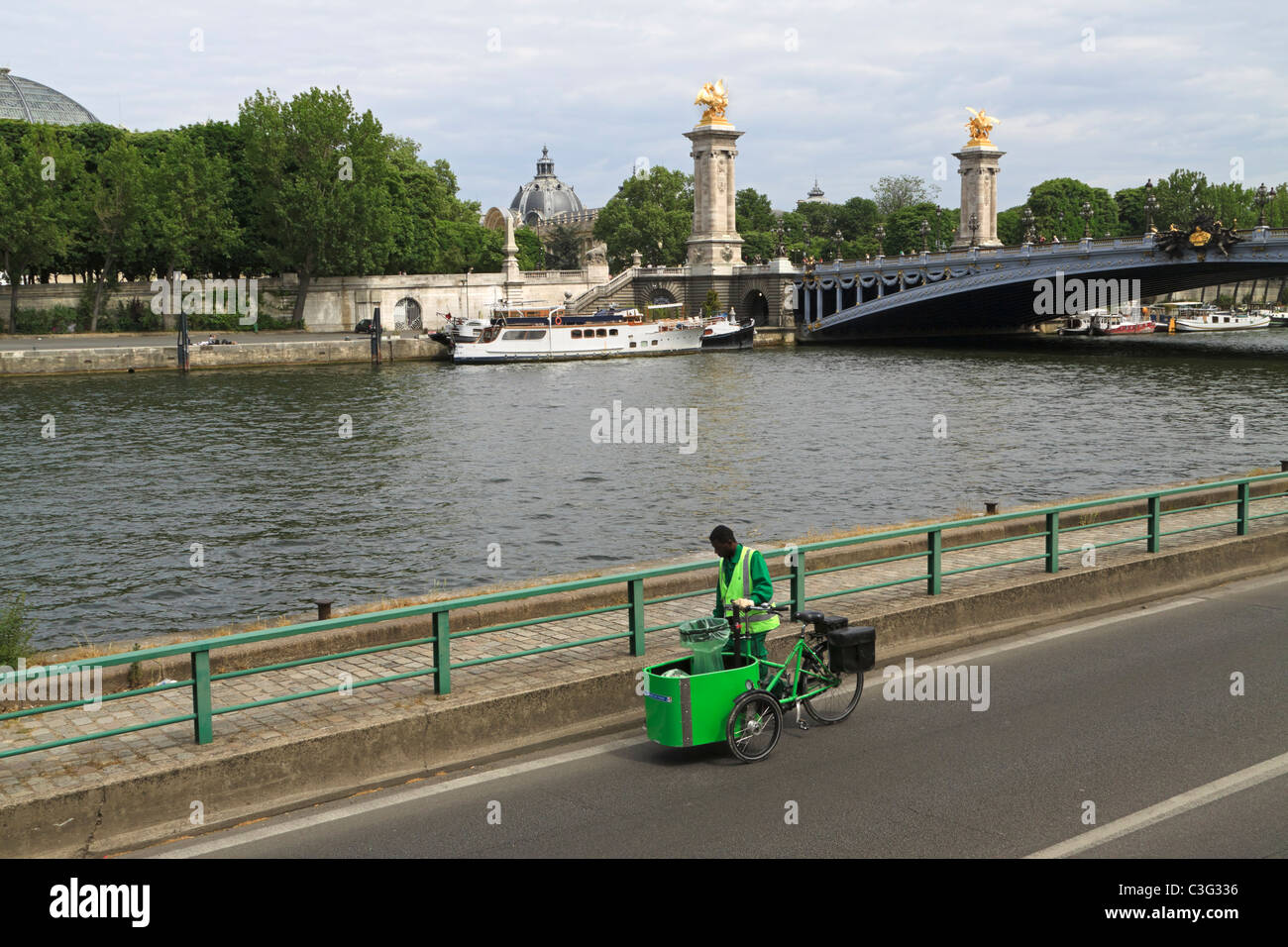 A street cleaner keeps the roads and pavements of Paris clean using a specially adapted three wheeled bicycle. Stock Photo