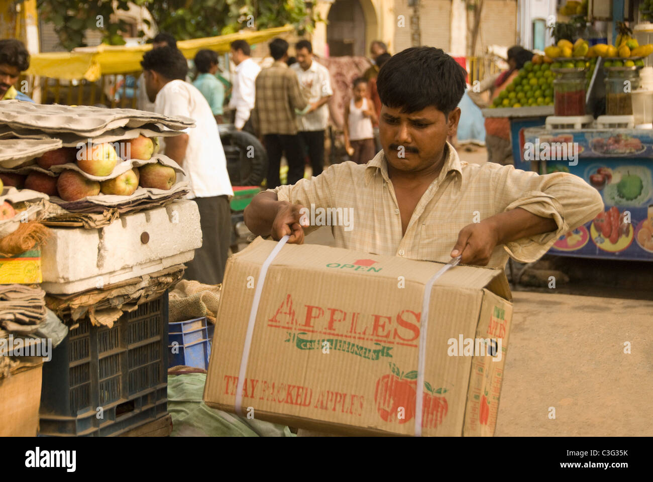 Man unloading apple carton at a street market, Chandni Chowk, Delhi, India Stock Photo
