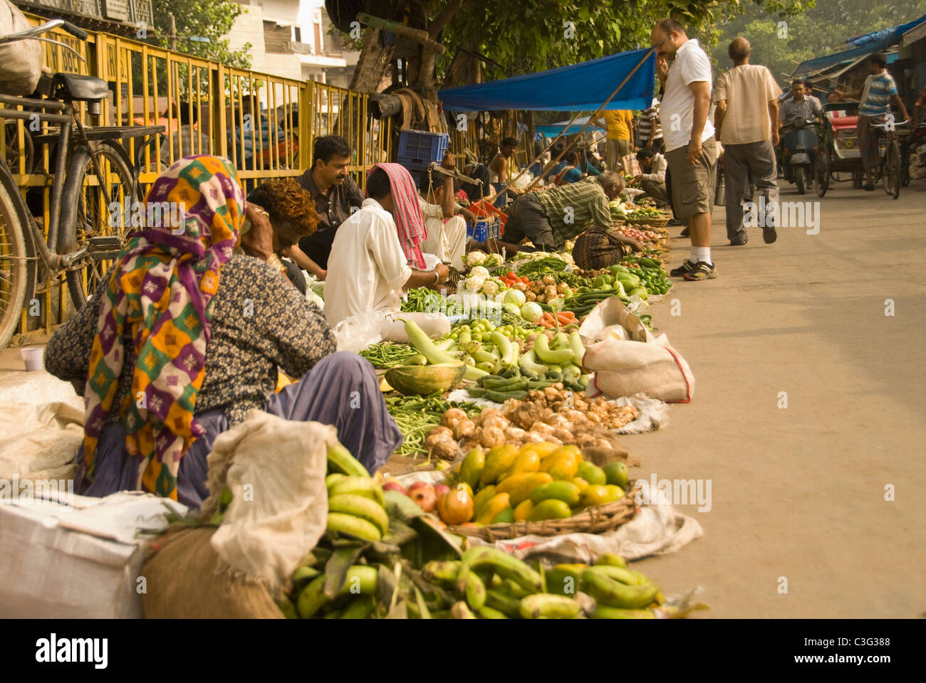 Market vendors selling vegetables at a market stall, Chandni Chowk, Delhi, India Stock Photo