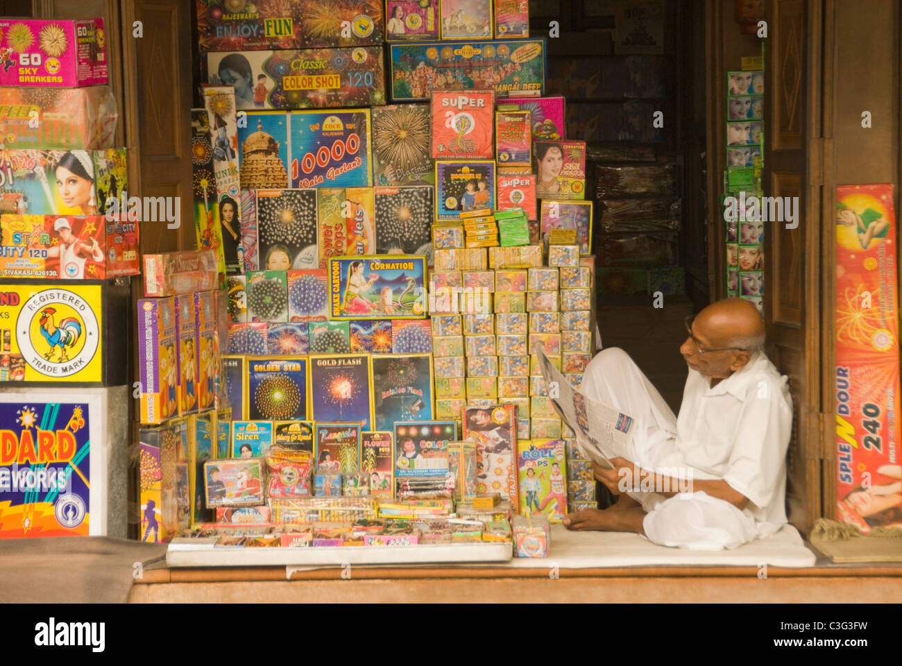 Vendor sitting in a fireworks store, Chandni Chowk, Delhi, India Stock Photo