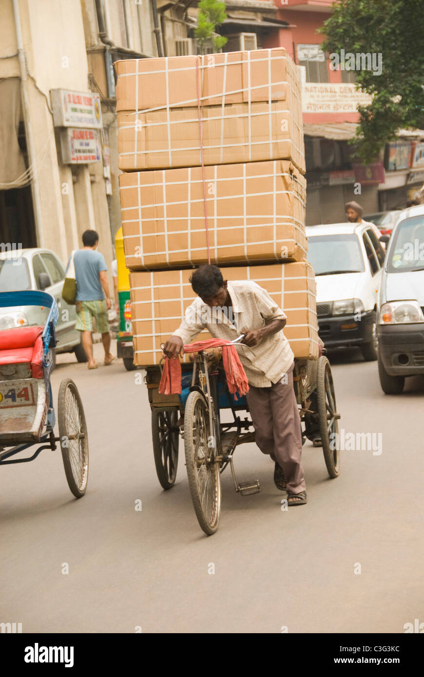 Man pulling an over loaded rickshaw, Chandni Chowk, Delhi, India Stock Photo