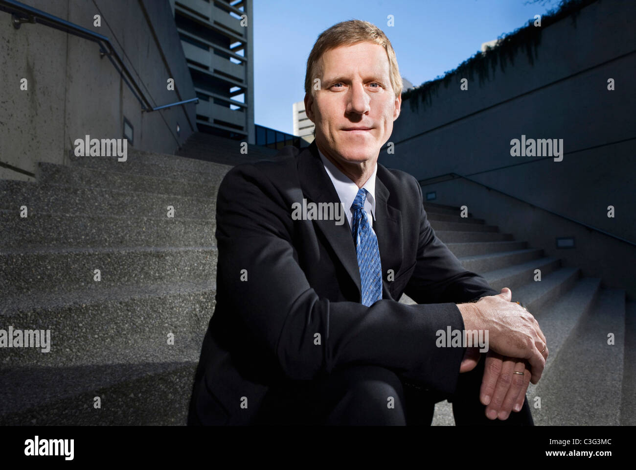 Caucasian businessman sitting on outdoor staircase Stock Photo