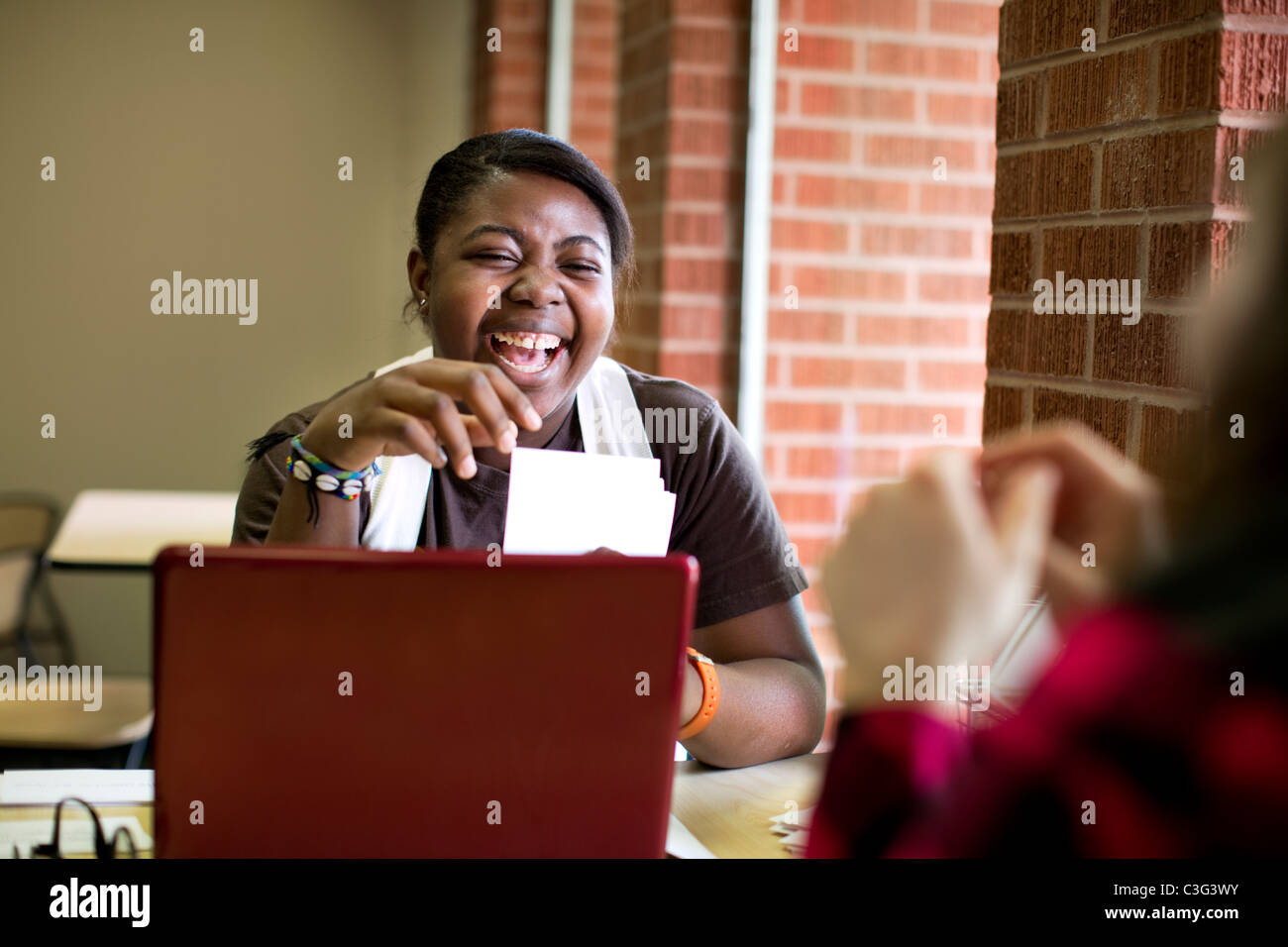 Laughing African American woman sitting in cafe Stock Photo