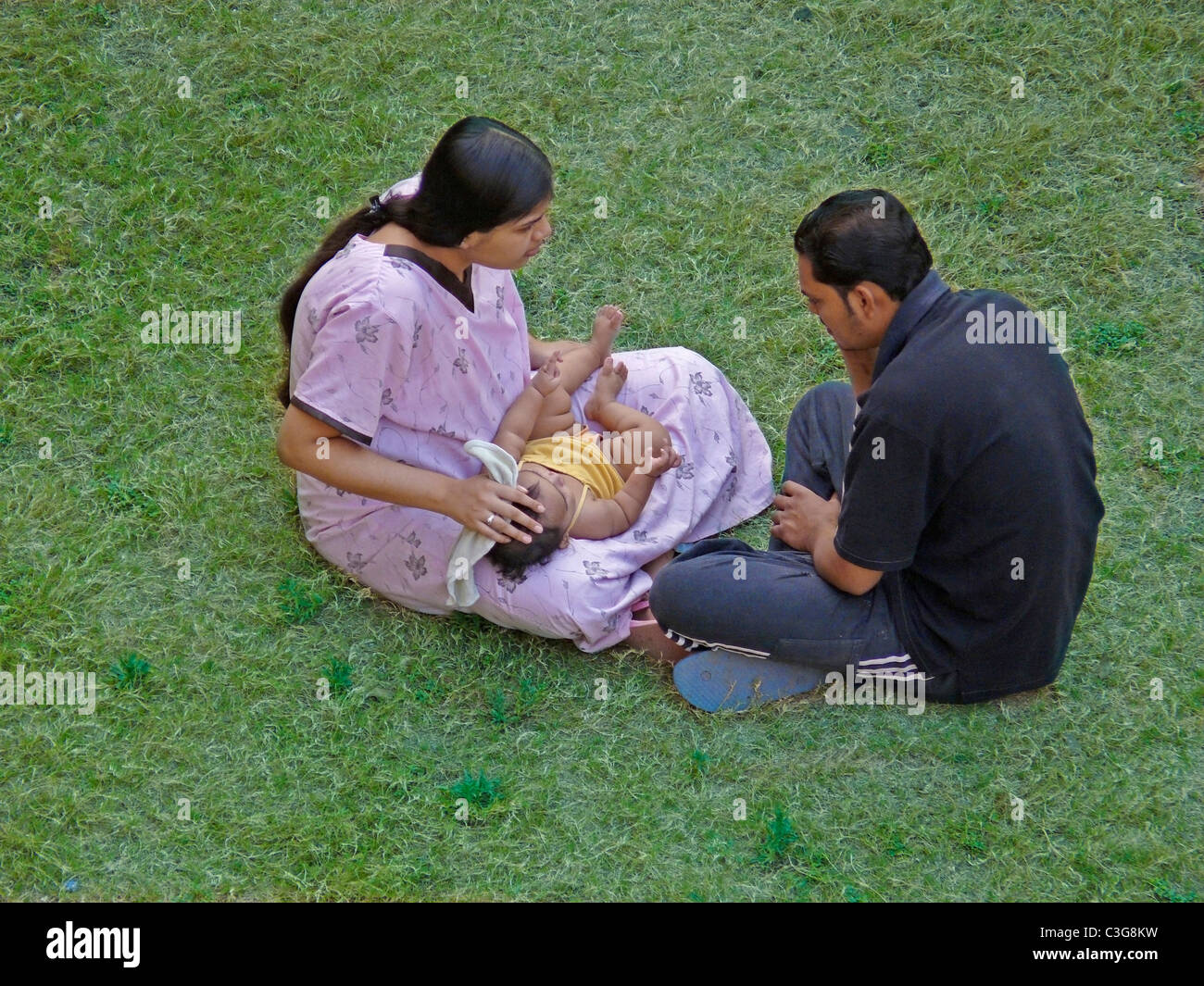 young-couple-with-their-baby-are-seating-in-a-garden-stock-photo-alamy