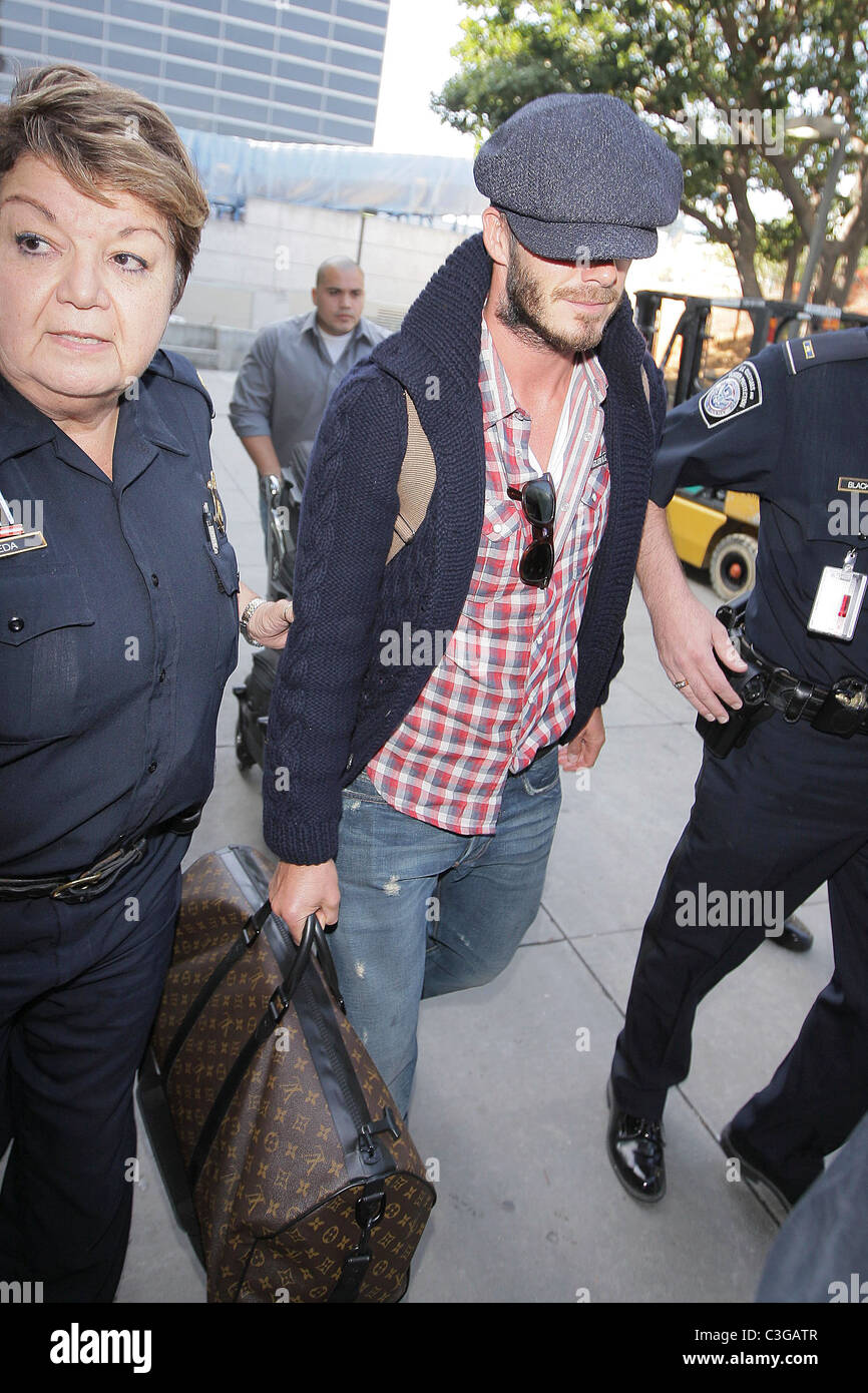 David Beckham, carrying his Louis Vuitton travel bag, gets a police escort  as he arrives at LAX airport on a British Airways Stock Photo - Alamy