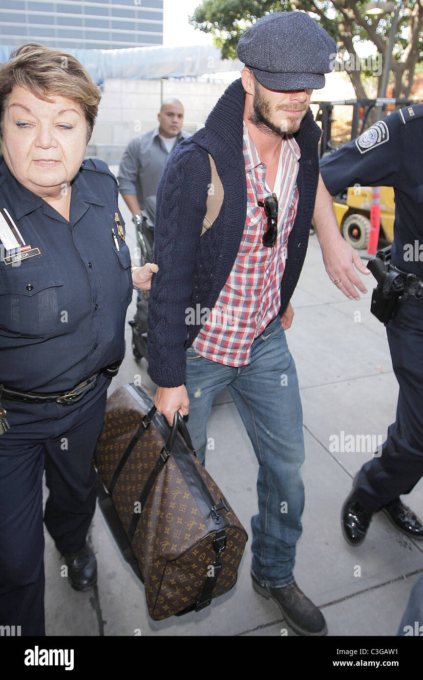 David Beckham, carrying his Louis Vuitton travel bag, gets a police escort  as he arrives at LAX airport on a British Airways Stock Photo - Alamy