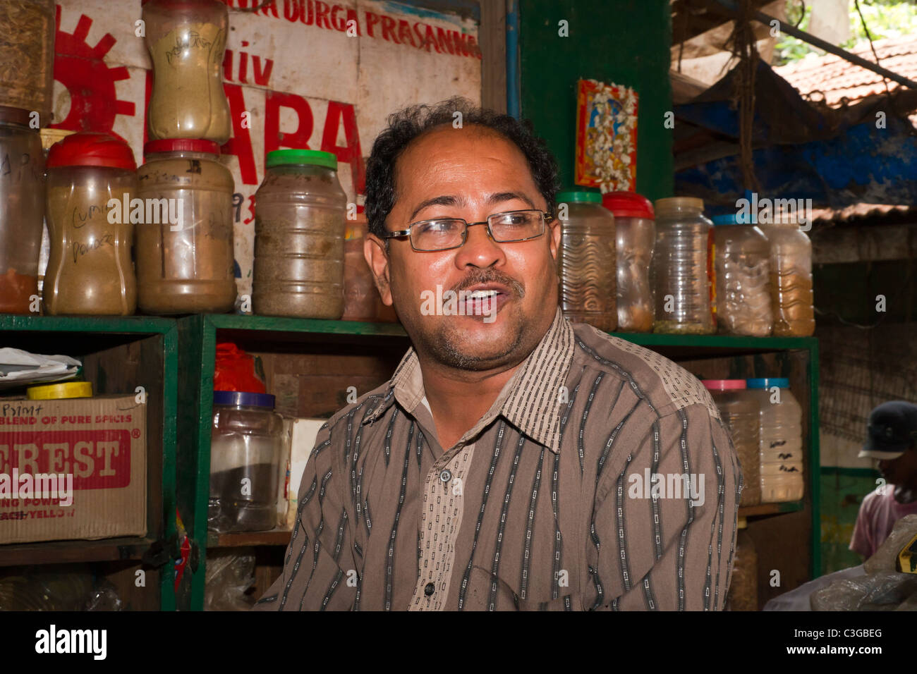 The stallholder an Asian male at is spice stall in Calangute market, Goa India Stock Photo