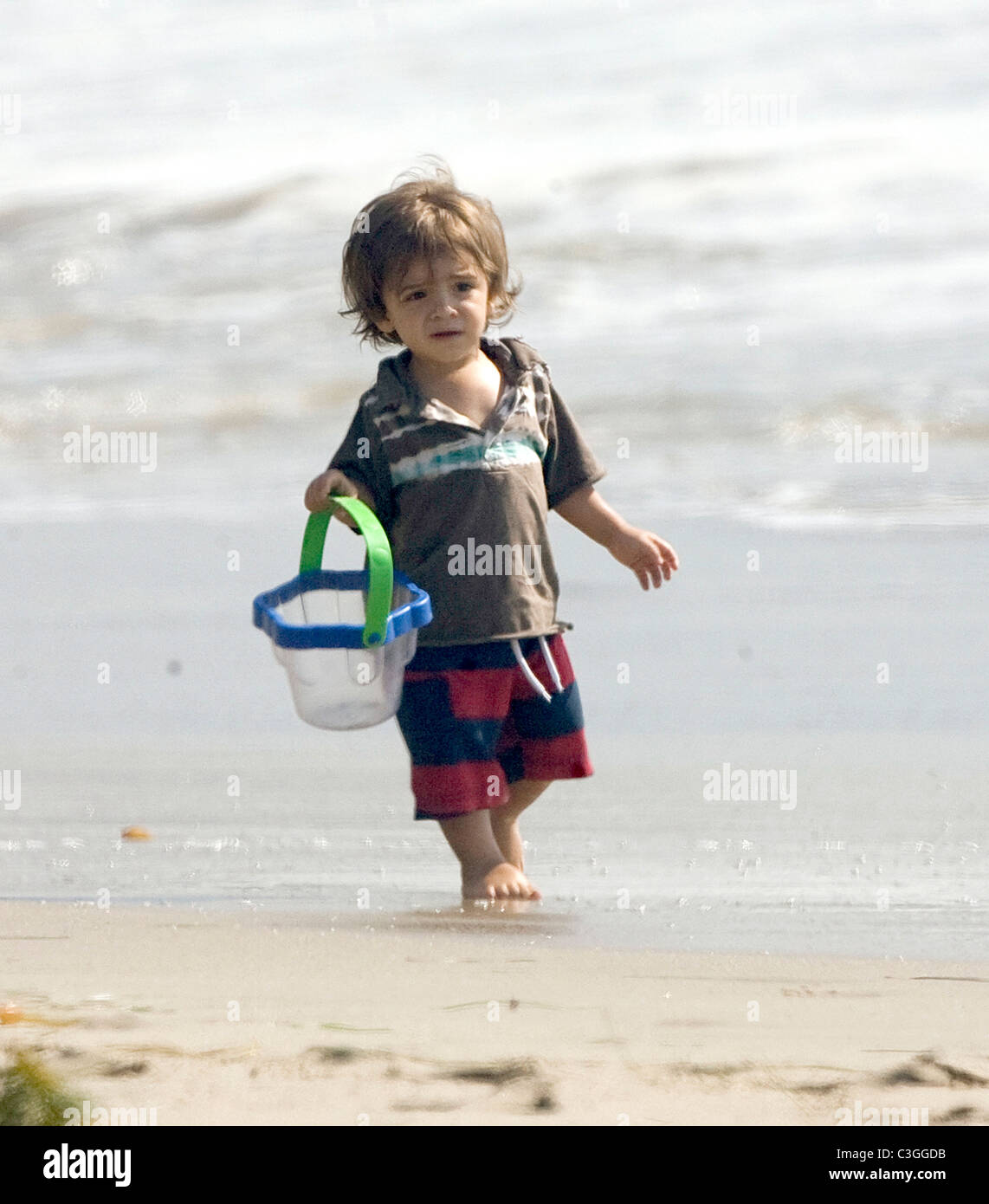 Levi McConaughey plays with his father and his dogs on a beach in