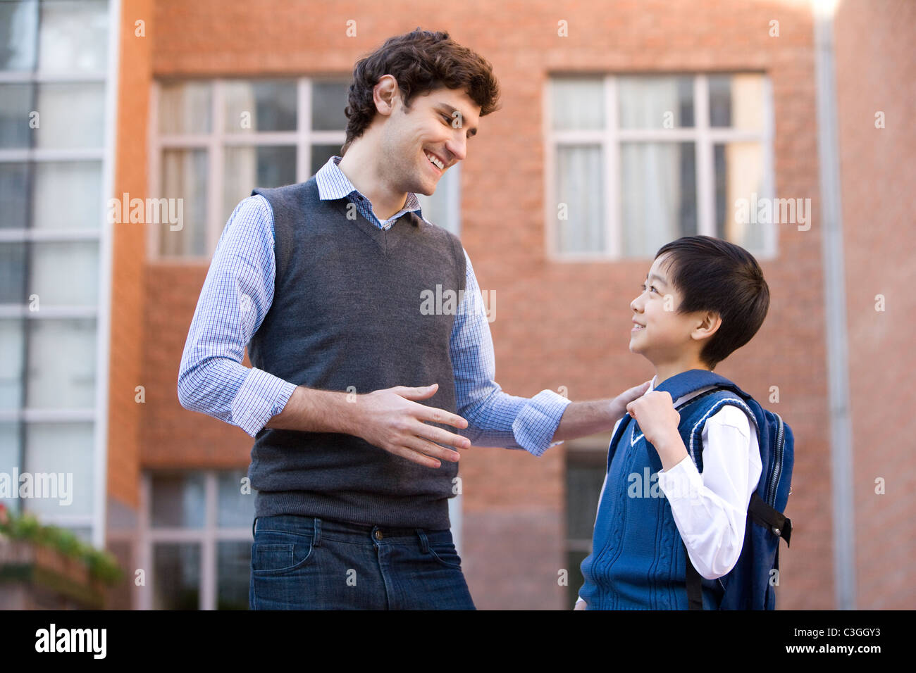 Teacher talking with a student on campus Stock Photo - Alamy