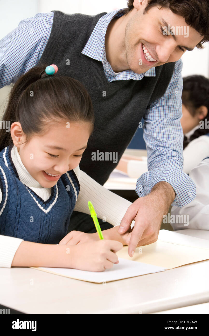 Teacher assisting student in class Stock Photo - Alamy