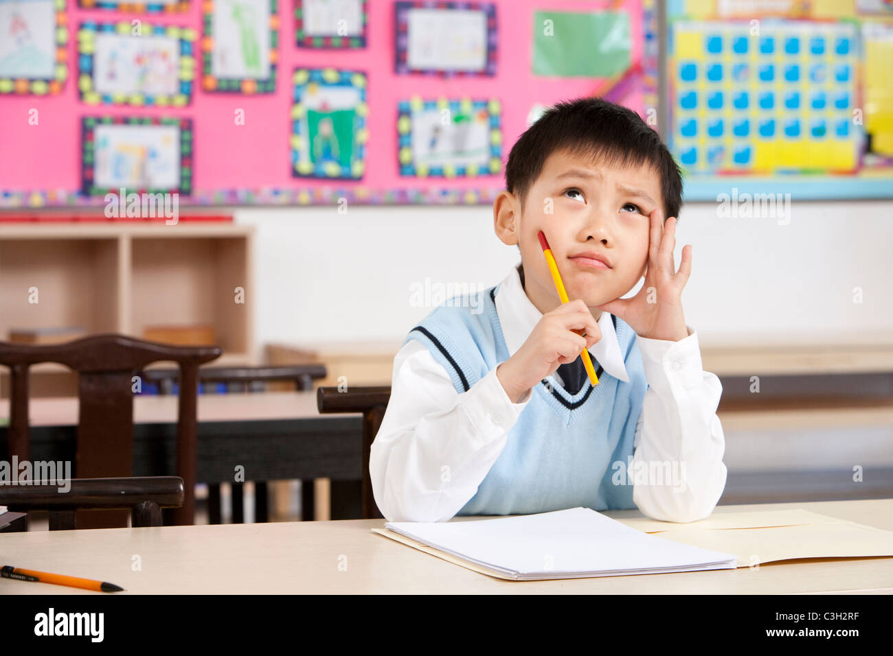 Young student writing in classroom Stock Photo