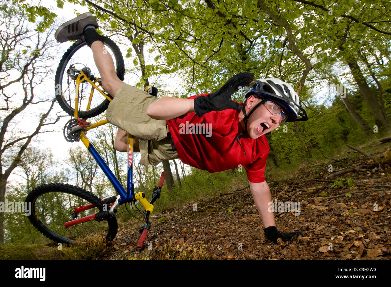Young man falling off of bicycle dramatically Stock Photo
