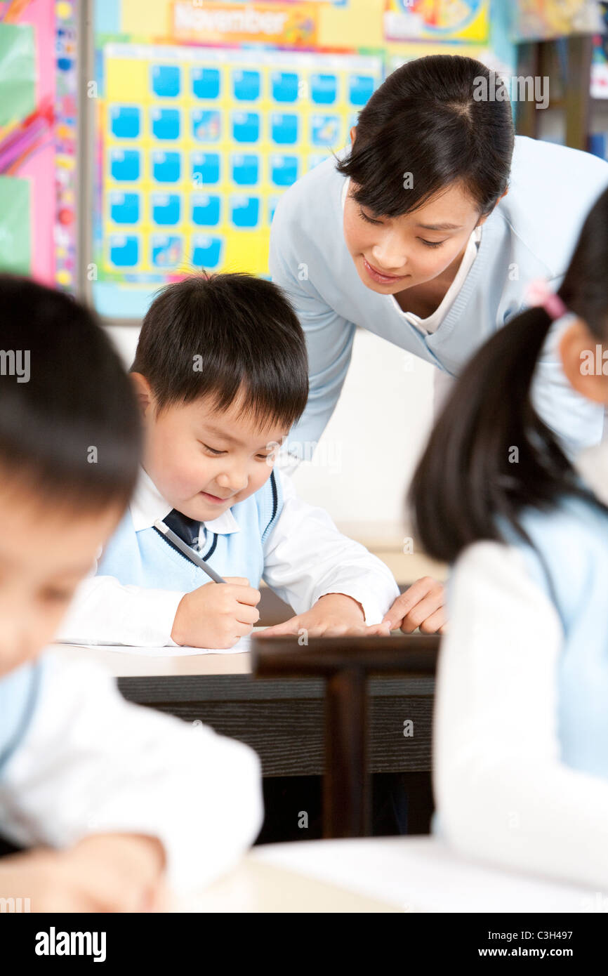 Teacher Assisting Student In Class Stock Photo - Alamy