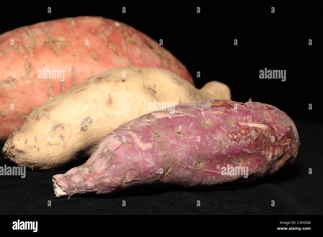 Three Kinds of Sweet Potatoes that is purple skin with white flesh, white skin with purple flesh and the normal orange sweet one Stock Photo