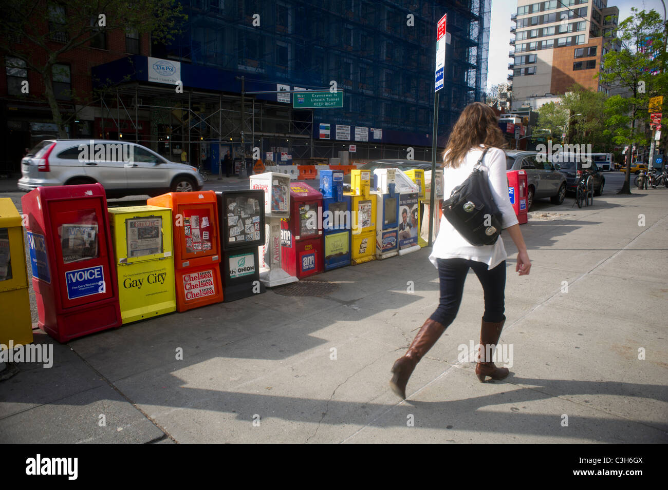 Newspaper distribution boxes lined up on a street corner in the New