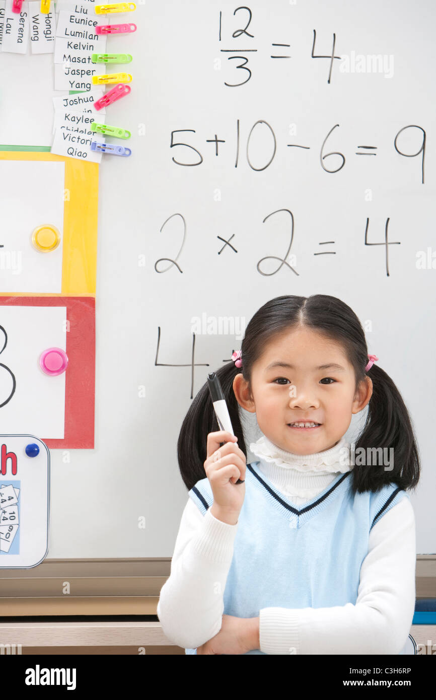 A young student standing proudly in front of her work Stock Photo