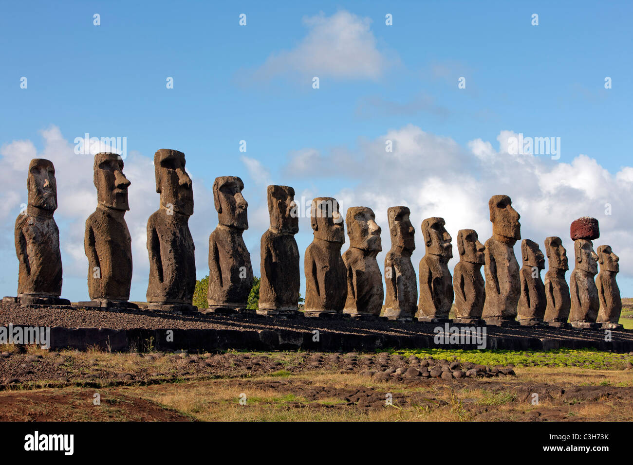 The fifteen Moais at Ahu Tongariki, one still with a topknot. Easter Island. Stock Photo