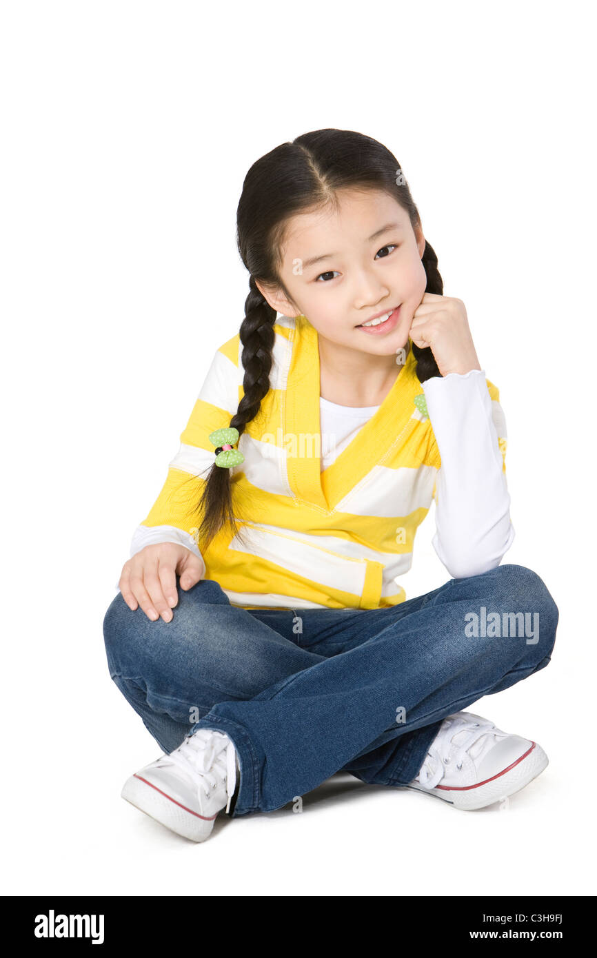 Young girl sitting with her hand on her chin Stock Photo - Alamy