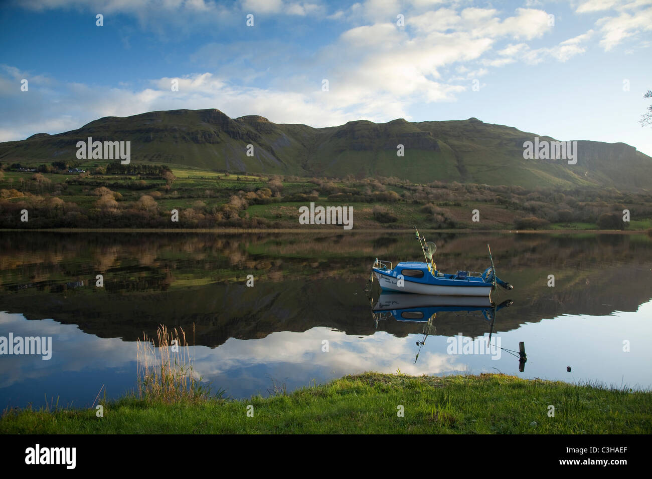 Mountain reflection and fishing boat in Glencar Lough, County Sligo, Ireland. Stock Photo