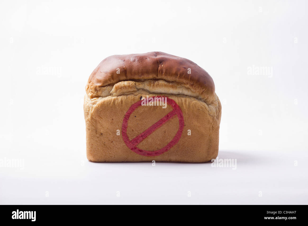 TRADITIONAL LOAF OF BREAD WITH A WARNING SIGN PAINTED ON IN RED Stock Photo