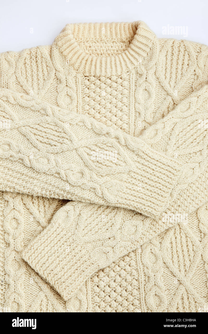 A traditional Irish Aran woolen sweater hand knitted in thick wool báinín yarn for winter warmth. UK Britain Stock Photo