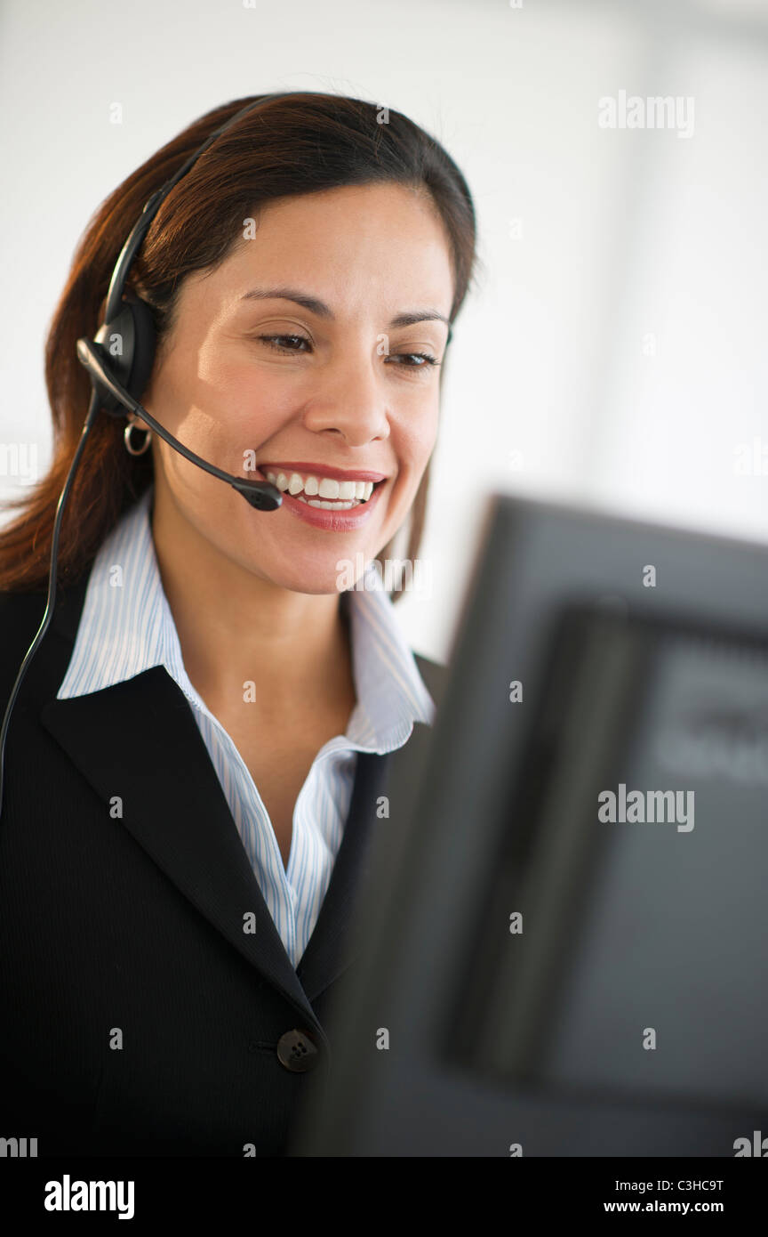Smiling female customer service representative with headset Stock Photo ...
