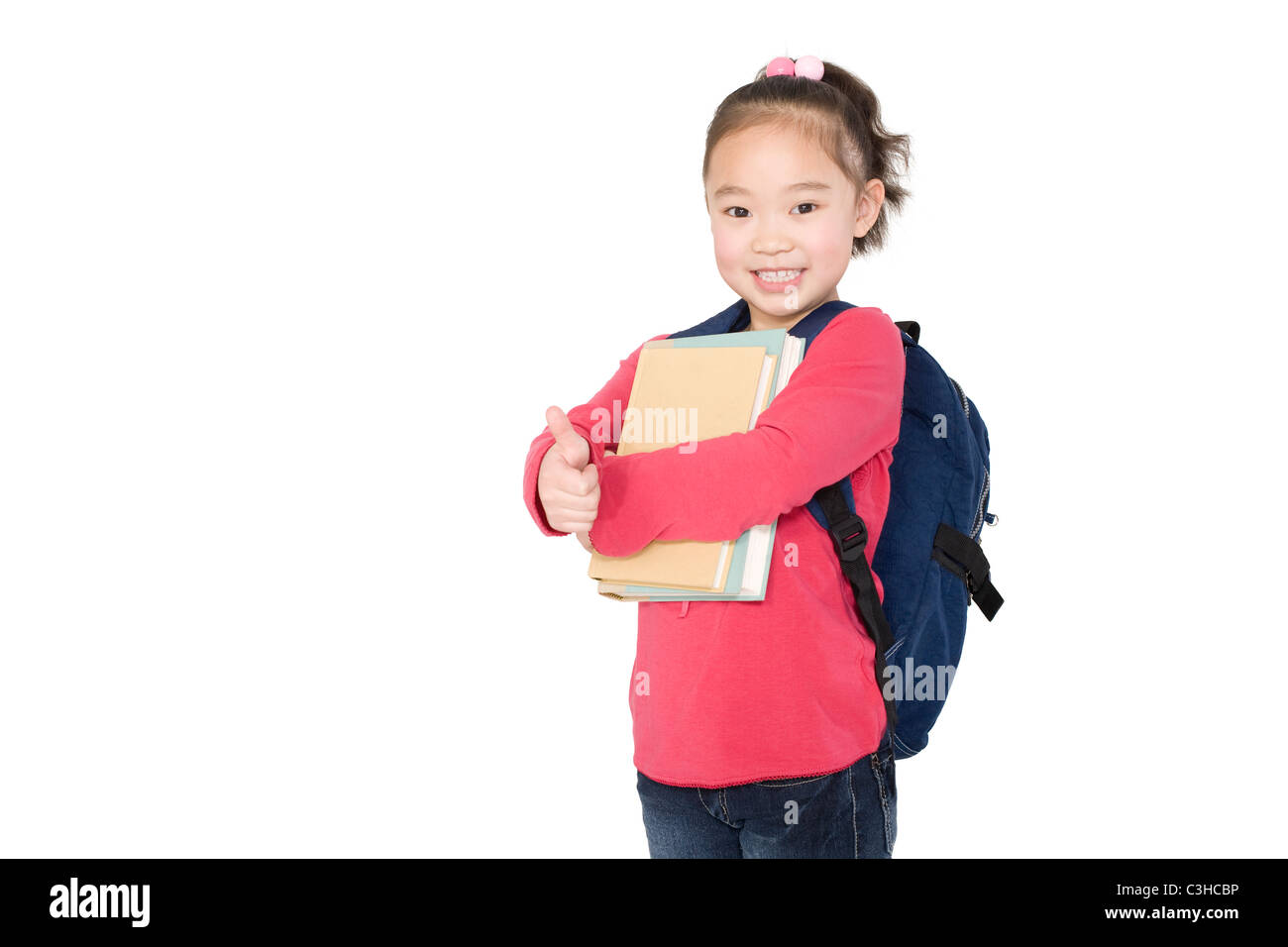 A young girl holding books and giving a thumbs up Stock Photo - Alamy