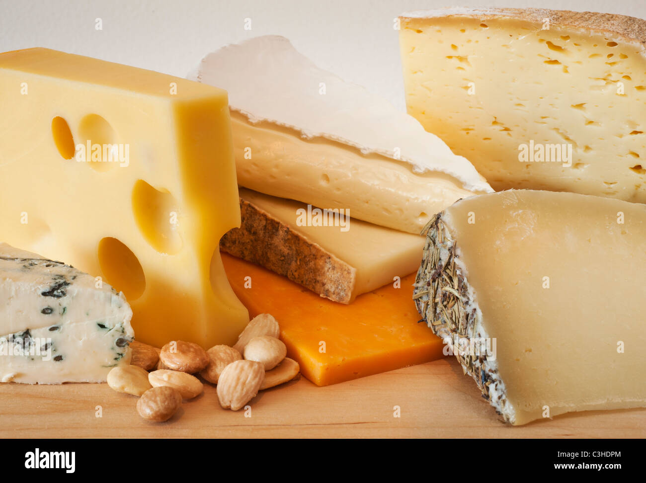 Various cheeses on chopping board Stock Photo