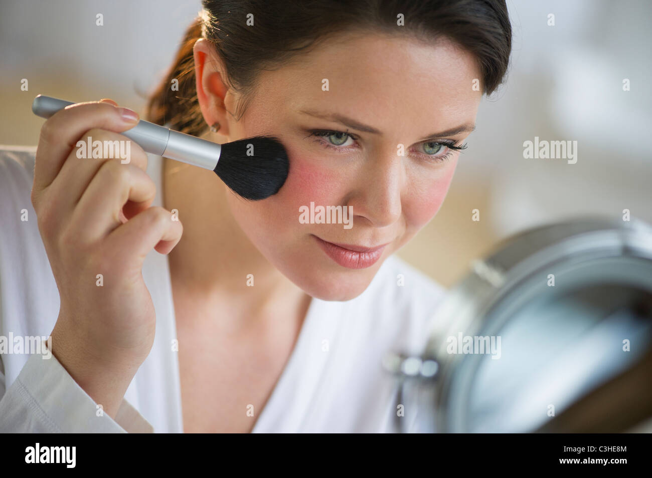 Woman applying blush on cheekbones Stock Photo Alamy