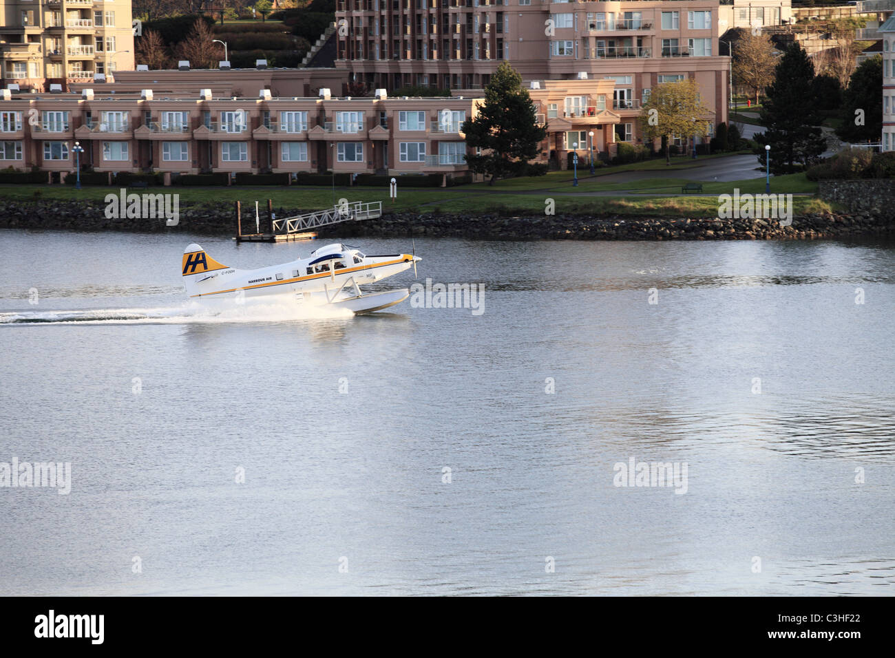 A sightseeing pontoon plane landing on the water of Victoria Harbor in Victoria , Vancouver Island, British Columbia. Stock Photo