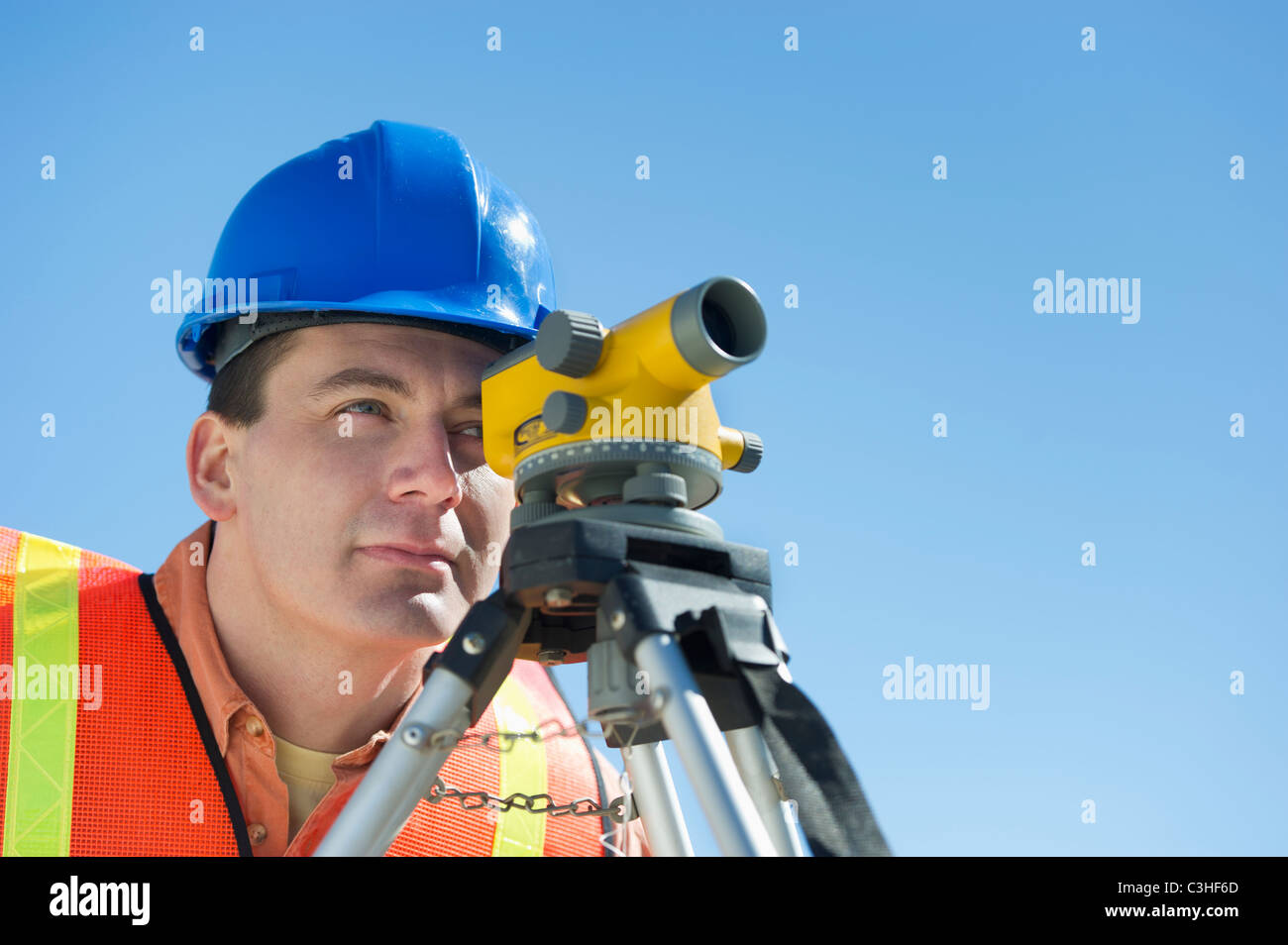 Construction worker in hard hat using theodolite Stock Photo