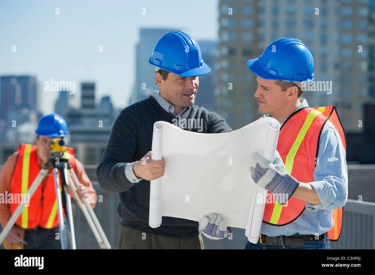 Construction workers reading blueprint Stock Photo Alamy