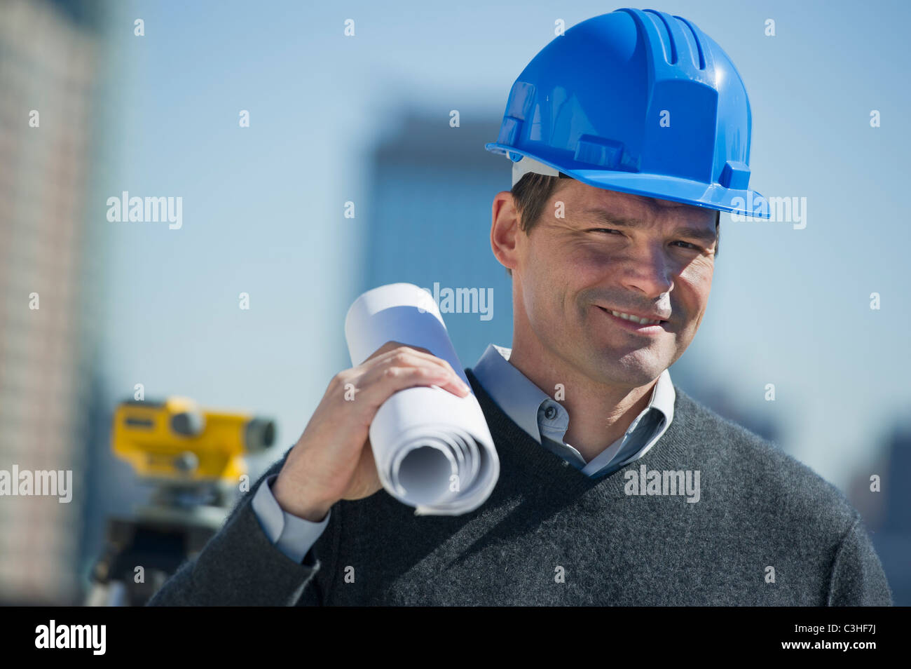 Portrait of construction worker holding rolled up blueprint Stock Photo ...