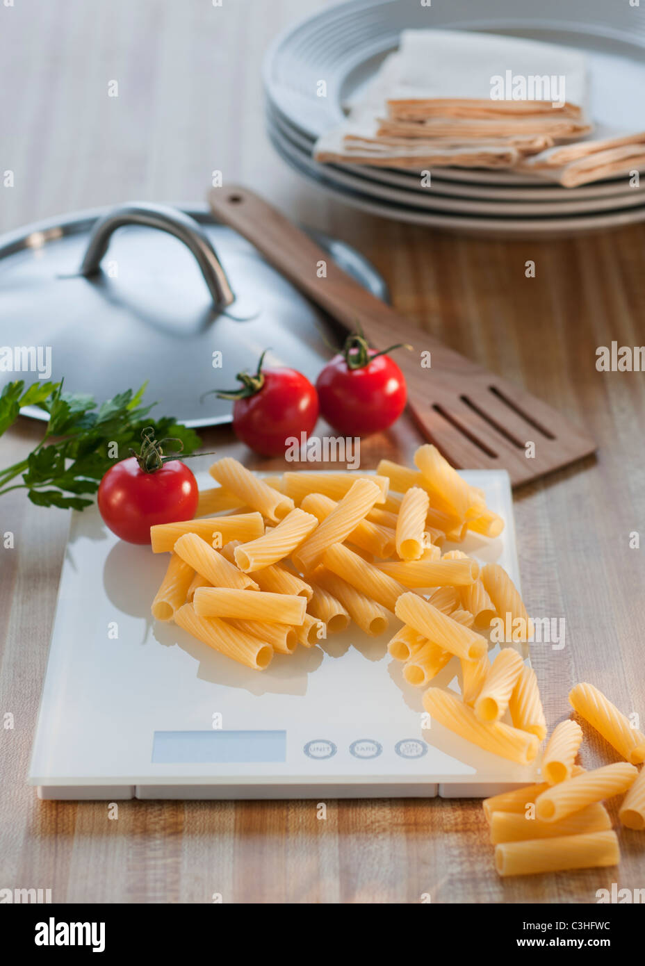 Raw pasta on weight scale Stock Photo