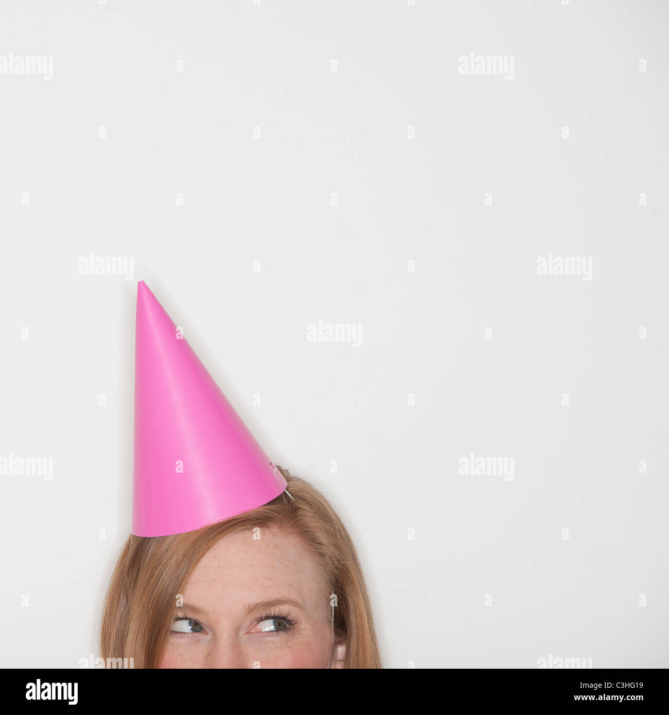 Studio shot of woman wearing pink party hat Stock Photo