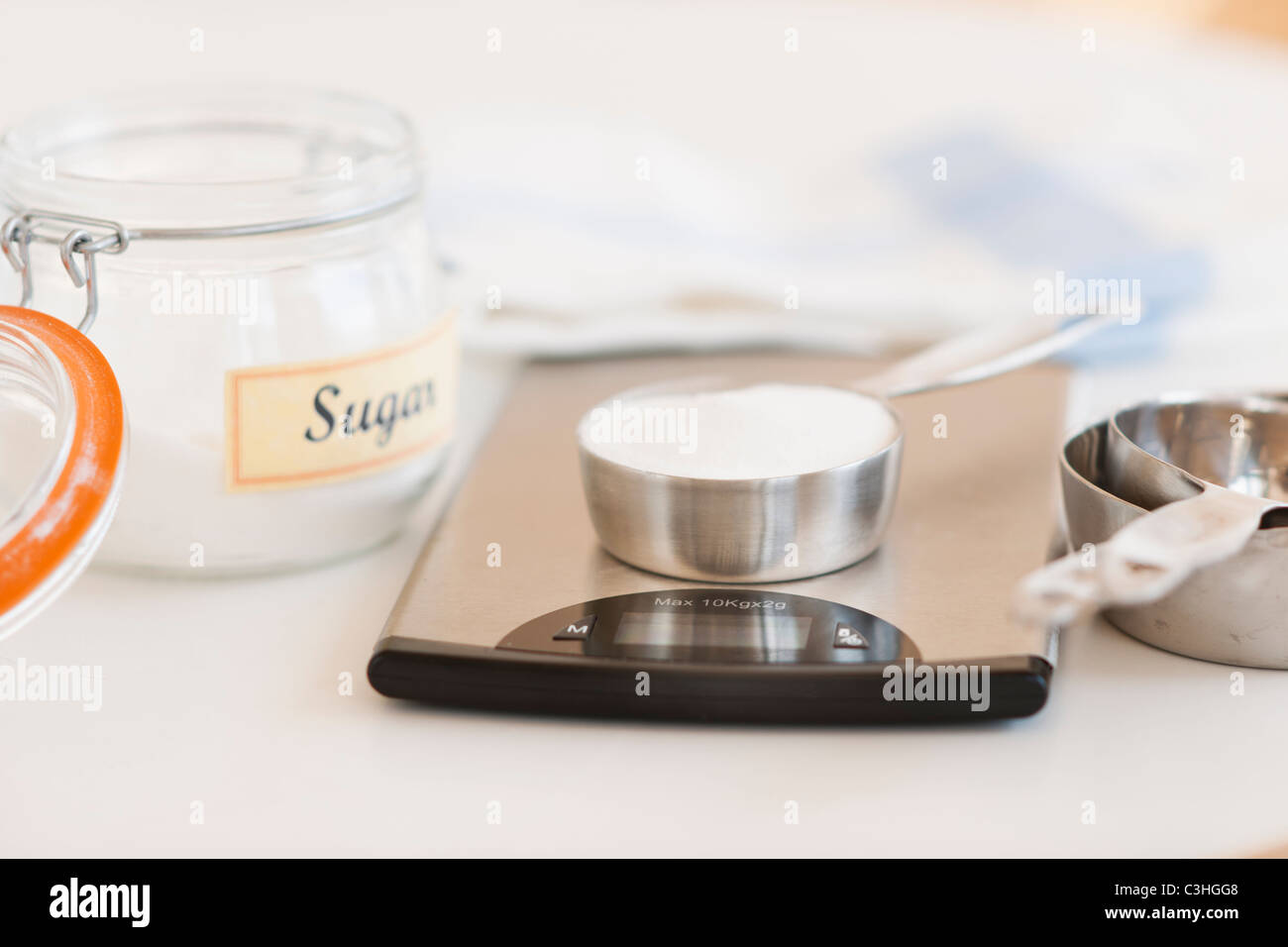 Spoon of sugar on weight scale Stock Photo