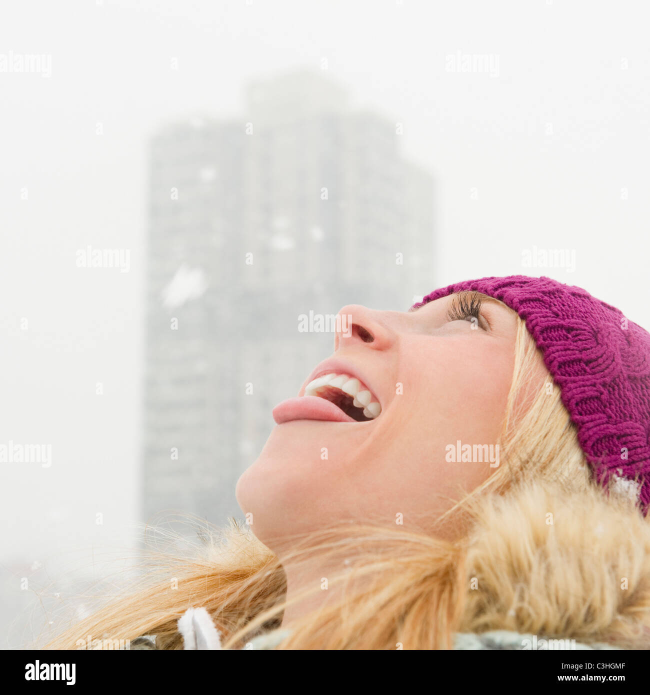 Woman catching snowflakes with tongue Stock Photo