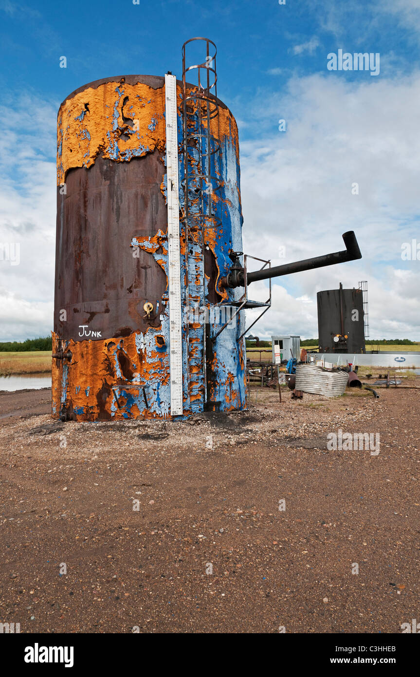 Industrial landscape: a deactivated crude oil storage tank sits in the middle of a grain field, Saskatchewan, Canada. Stock Photo