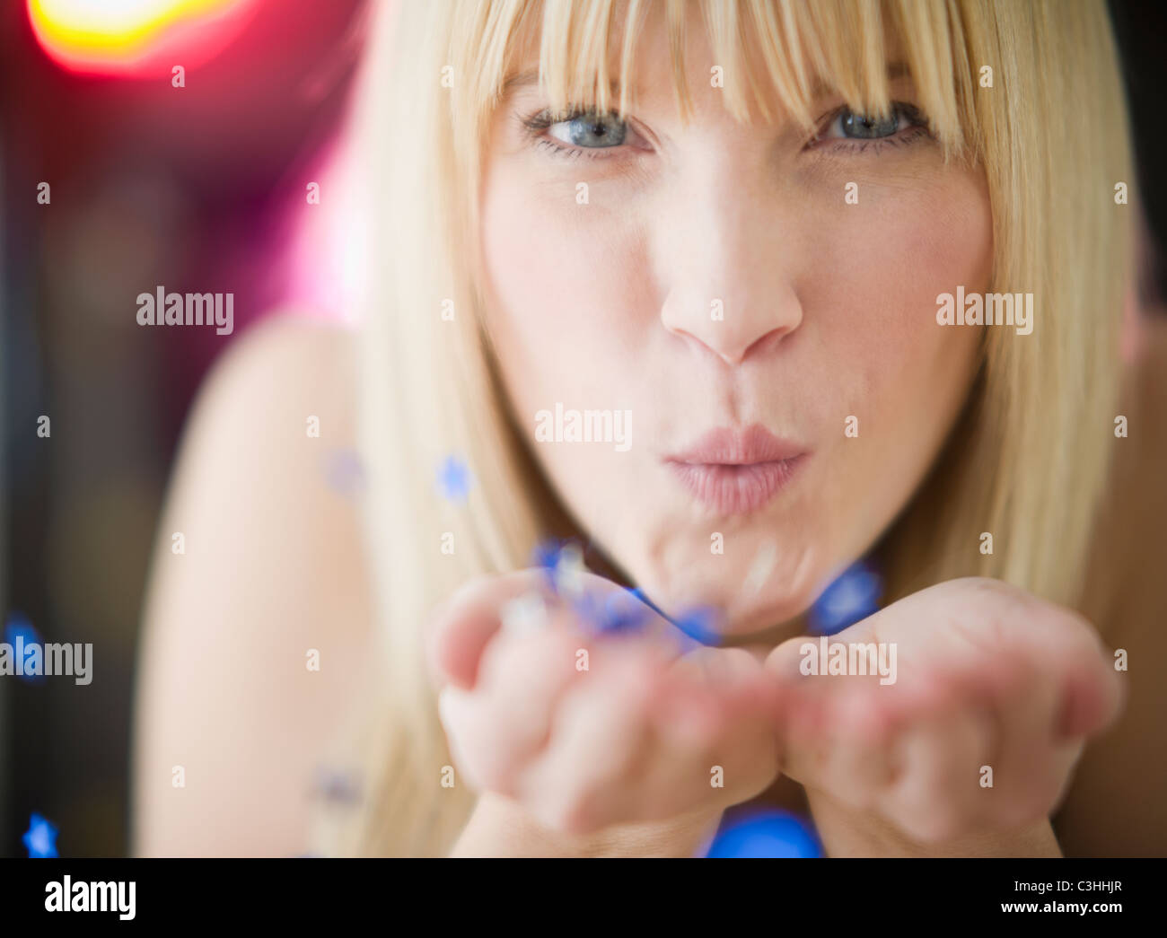 Young woman blowing confetti Stock Photo