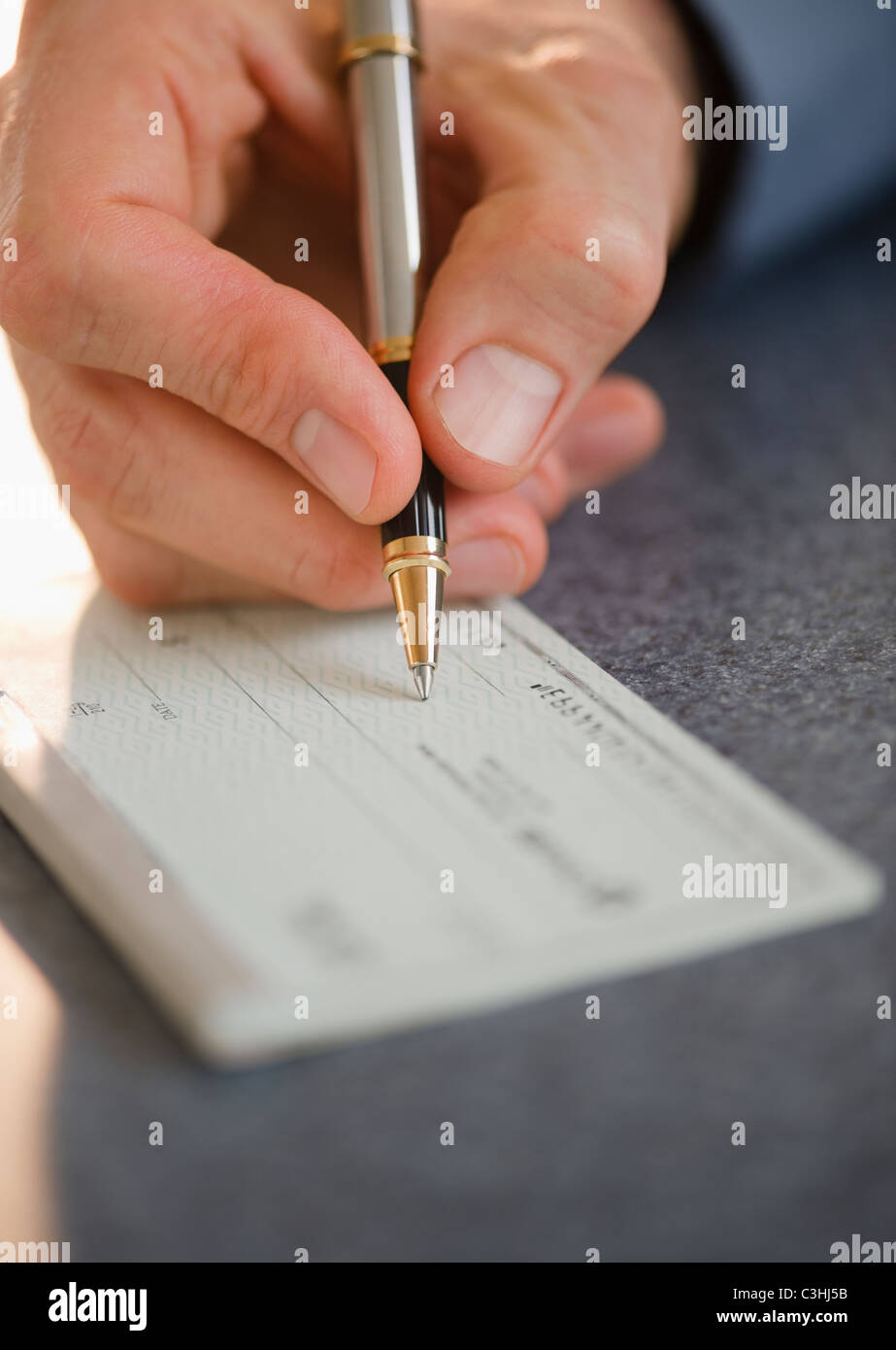 Hand signing check Stock Photo Alamy