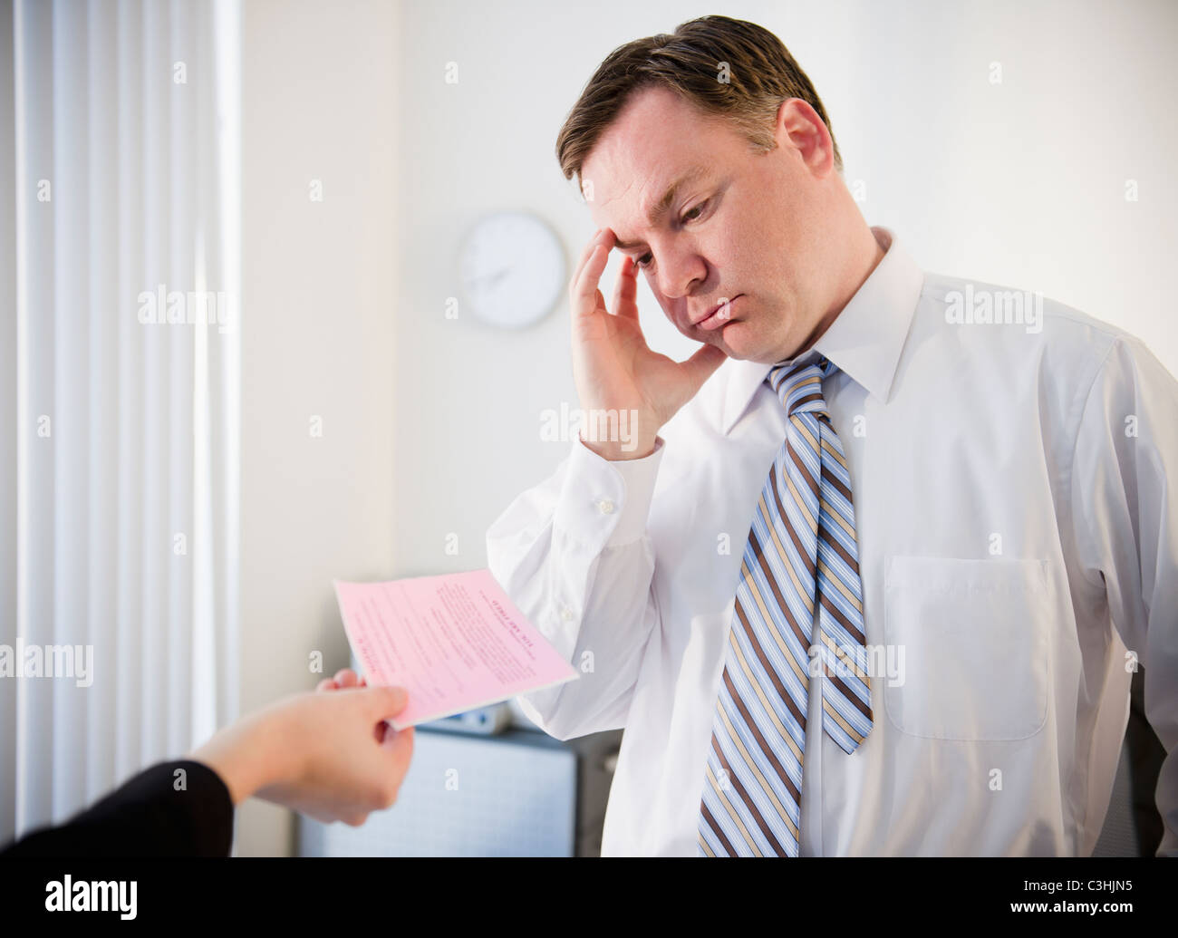 Businessman getting pink slip Stock Photo