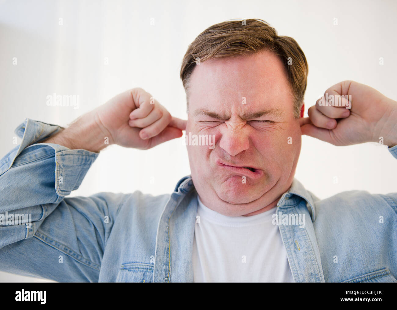 Man blocking ears with fingers Stock Photo Alamy