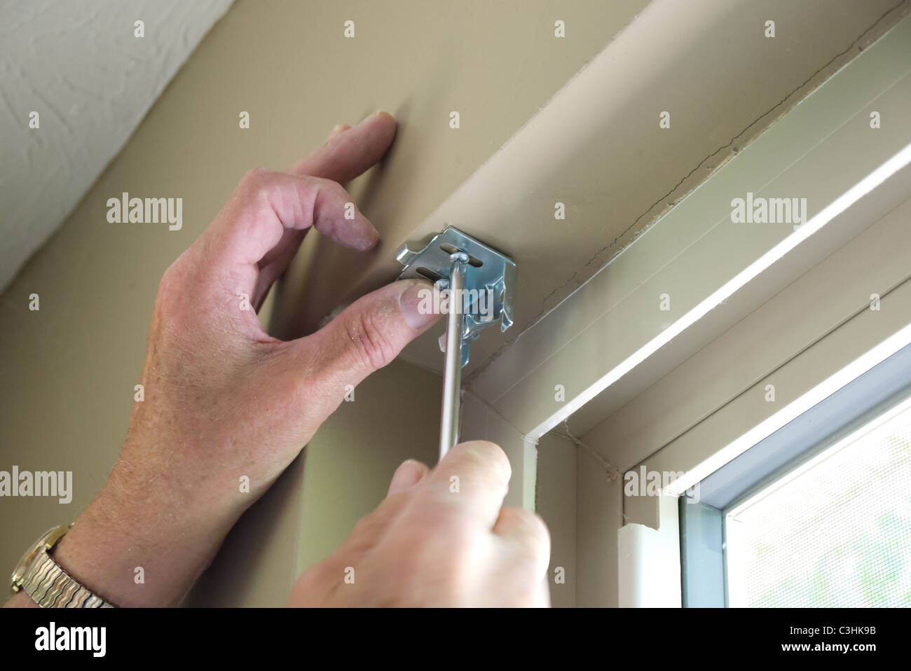 Hands installing blind hardware onto window frame Stock Photo Alamy