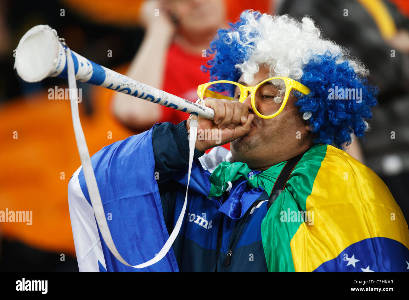 A spectator blows a vuvuzela at a FIFA World Cup football match between Brazil and Côte d'Ivoire June 20, 2010. Stock Photo