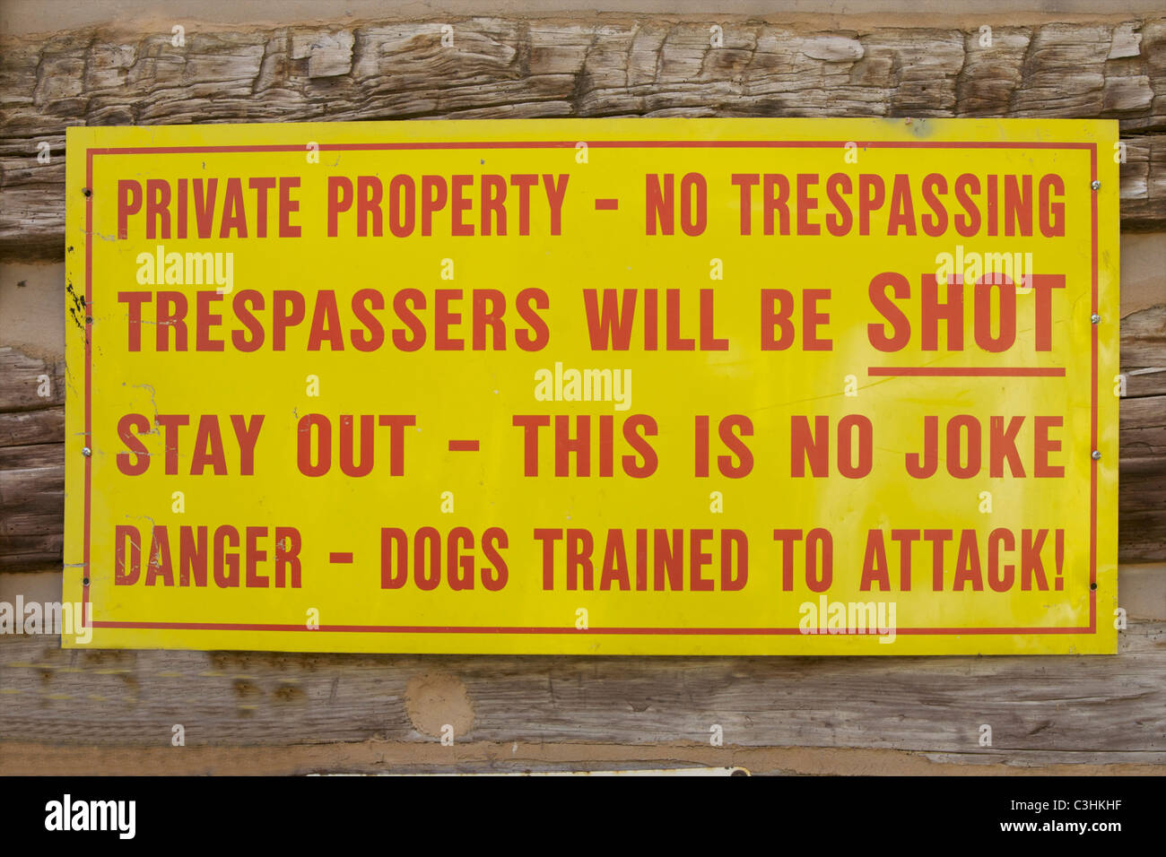 No trespassing sign on the side of a log cabin. Stock Photo