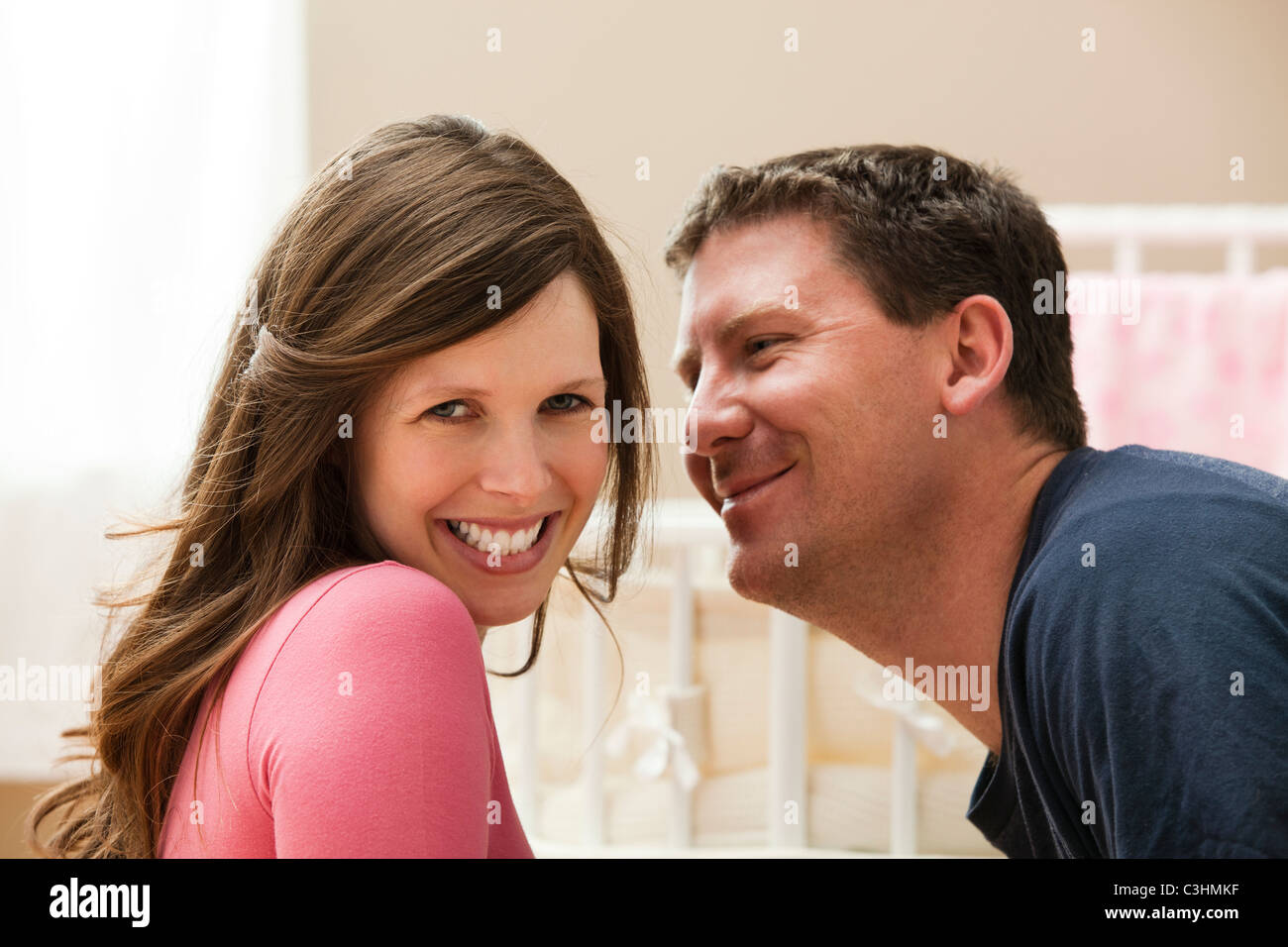 Young pregnant woman about to be kissed by mid adult man Stock Photo ...