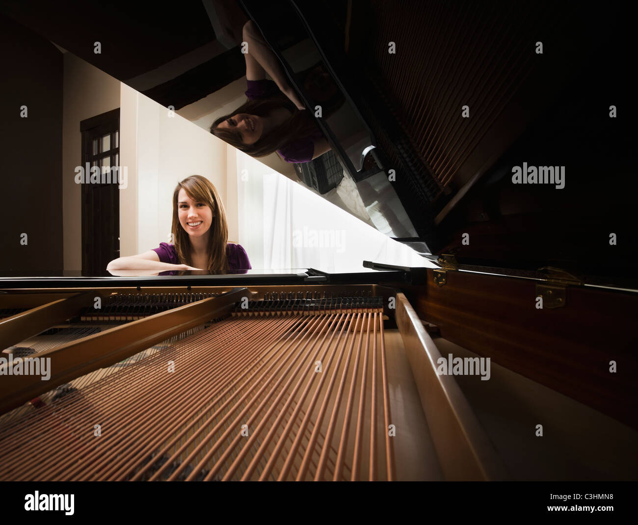 Portrait of young pianist sitting by grand piano Stock Photo